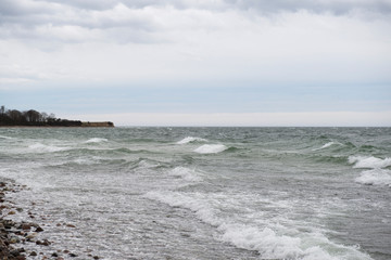 View of the baltic sea and stone beach, stormy sea waves 