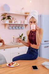 Busy young businesswoman drinking morning coffee at home