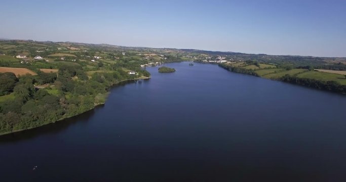 pulling back over lake with view of skyline, drone footage