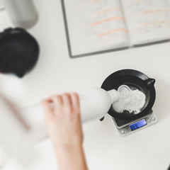 Closeup of hairdresser weighing proportion of hair dye on electronic scales