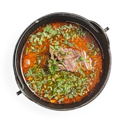 Red soup with meat and vegetables, top view, on white background