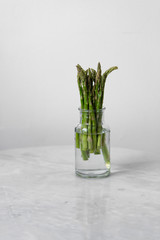 Fresh asparagus in an glass on marble background with copy space