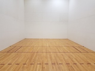 wood floor racquetball court with white walls