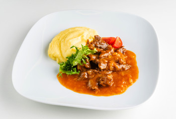 meat with mashed potato on the white plate