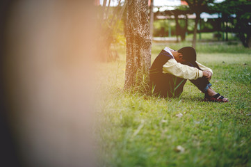 Picture of a young boy sitting sadly alone in the forest Depression concept