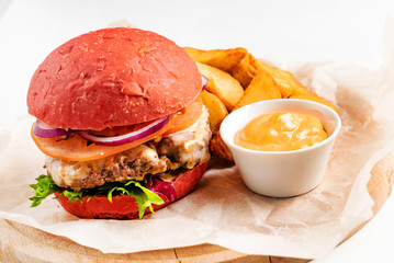 red burger with roasted potatoes and sauce