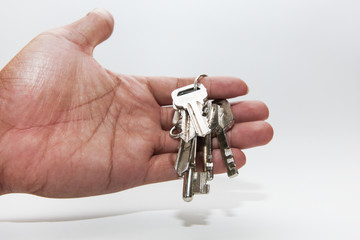 A hand holding a metal key  are isolated on a white background