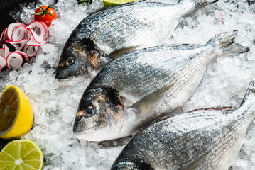 Fresh raw dorado fish and food ingredients on table