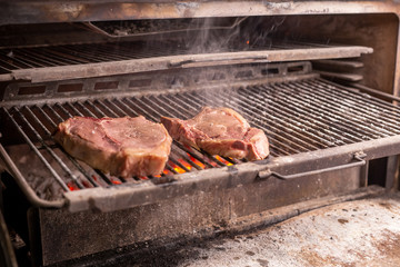 food, craft and delicious concept - cooking steak on a grill