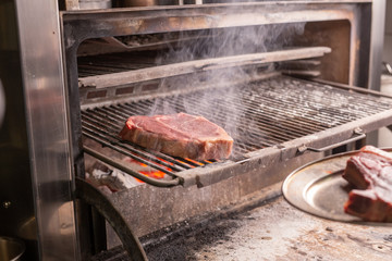 food, craft and delicious concept - cooking steak on a grill