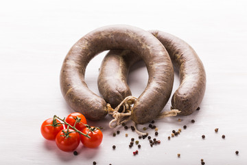 Food, horse meat and delicious concept - sliced sausage with tomato and pepper
