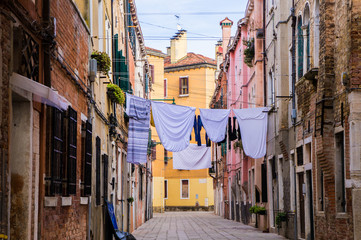 Narrow colourful street in Venice with clothes hanging drying 