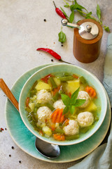 Healthy and tasty lunch. Baby food. Dietary Summer light vegetable soup with meatballs on stone table. Copy space.