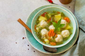 Healthy and tasty lunch. Baby food. Dietary Summer light vegetable soup with meatballs on stone table. Copy space.