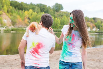 Pet, summer tourism, festival holi and nature concept - funny man and woman with cat on natural background