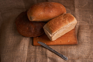 Frash assortment of baked bread on sacking background viewed from above. Top view