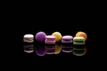 diffrent colorfull macarons on black background .pink, yellow, purple, green color macaroons 