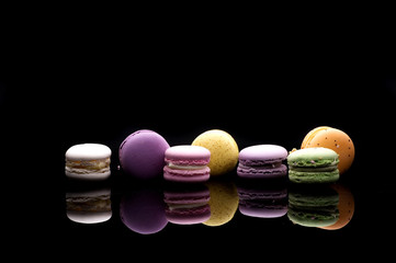 diffrent colorfull macarons on black background .pink, yellow, purple, green color macaroons 