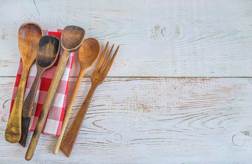 Vintage wooden utensil and checkered napkin on rustic white paint wooden background with copy space