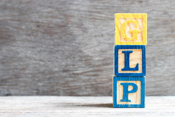 Color letter block in word GLP (Abbreviation of Good laboratory practice) on wood background