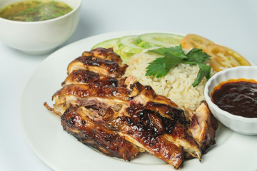 a plate of chicken rice with soup and sauce isolated on white background