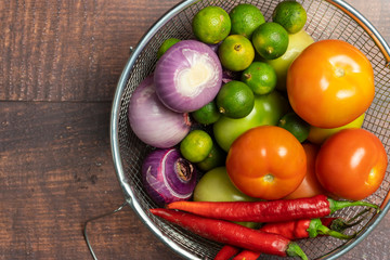 vegetables tomatoes, onions, limes, red peppers on wooden background