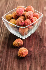 Fresh organic lychee fruit on brown wooden background