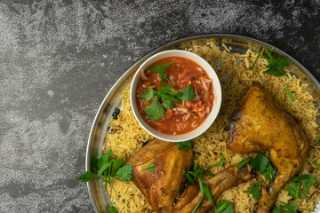 chicken mandy rice set with spicy sauce and salad on dark background