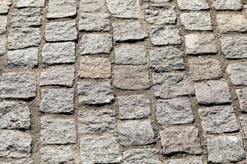 Background from equal ranks of a square stone on a floor. Floor stone blocks in the long term