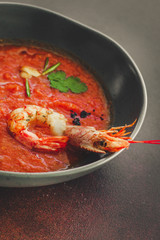 Gazpacho red soup with prawns shrimps (tomato soup with seafood) serving. food background. copy space