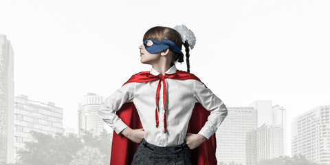 Obraz premium Girl power concept with cute kid guardian against cityscape background