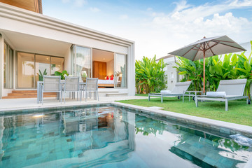 home or house Exterior design showing tropical pool villa with greenery garden, sun bed, umbrella,...