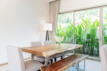 Luxury interior design in living room of pool villas. Airy and bright space with high raised ceiling and kitchen area with dining table