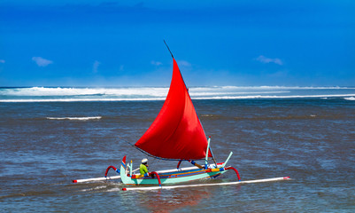 Red sail on a traditional wooden boat in Bali