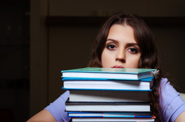 Young female student preparing for exams late at home 