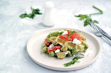 Light dinner, lunch or brunch, savory spinach snack waffles with salted salmon and cream cheese on a ceramic plate. Healhy food.