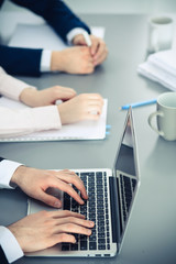 Group of business people working together in office. Man hands typing on laptop computer