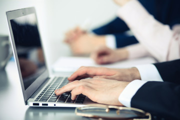 Obraz premium Group of business people working together in office. Man hands typing on laptop computer