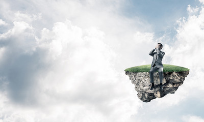 Young man on floating island in blue sky do not want to see anything