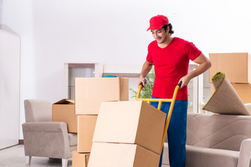 Young male contractor with boxes working indoors 