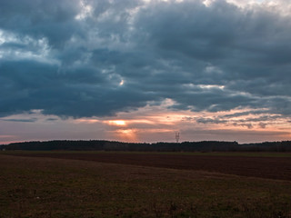 Fototapeta na wymiar Promienie słońca przebijające się przez grubą warstwę ciemnych chmur.