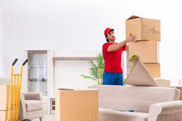 Young male contractor with boxes working indoors 