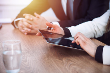 Group of business people or lawyers  work together at meeting in office, hands using tablet and making notes close-up. Negotiation and communication concept