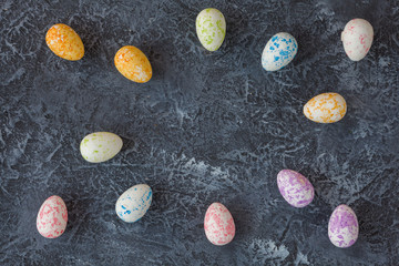 Fototapeta na wymiar Painted Easter eggs on dark stone background with copy space. Happy easter card. 