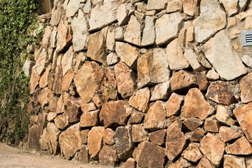 Structural stone wall in Spain from local stone as the base of the background.