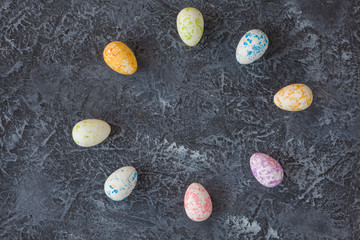 Fototapeta na wymiar Painted Easter eggs on dark stone background with copy space. Happy easter card. 