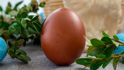Świąteczne jajko w otoczeniu koszyka i bukszpanu.