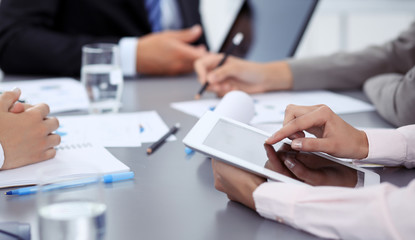 Woman hands using tablet at meeting. Business people group working together in office, close-up. Negotiation and communication concept