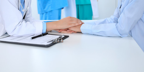 Hand of doctor  reassuring her female patient. Medical ethics and trust concept, white background