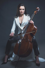 Beautiful woman in a white coat plays the cello